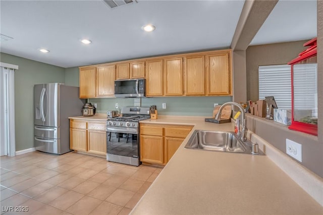 8320 Highland Ranch St, Las Vegas, NV 89131 - kitchen with stainless steel appliances, a sink, light countertops, light tile patterned floors, and light brown cabinetry