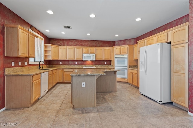 4883 Grey Mesa St, Las Vegas, NV 89149 - kitchen featuring white appliances, a sink, a center island, light brown cabinetry, and a breakfast bar