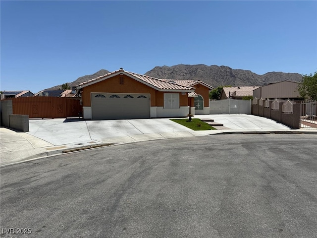 6248 Sapporo Cir, Las Vegas, NV 89110 - view of front of property with a gate, an attached garage, a mountain view, a tiled roof, and stucco siding