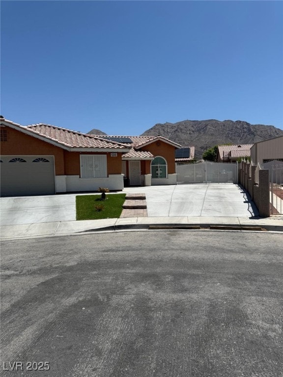 6248 Sapporo Cir, Las Vegas, NV 89110 - view of front of home with driveway, a tile roof, a mountain view, a garage, and stucco siding