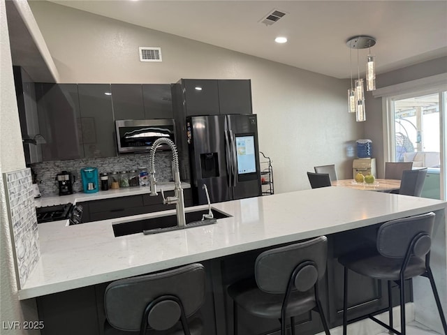 6248 Sapporo Cir, Las Vegas, NV 89110 - kitchen featuring stainless steel refrigerator with ice dispenser, lofted ceiling, a sink, a kitchen bar, and backsplash