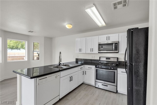 6117 Daisy Lee Ave, Las Vegas, NV 89108 - kitchen featuring appliances with stainless steel finishes, a sink, a peninsula, and light wood-style flooring