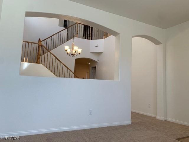 3728 Prairie Orchid Ave, North Las Vegas, NV 89081 - unfurnished living room with a chandelier, carpet flooring, arched walkways, and baseboards