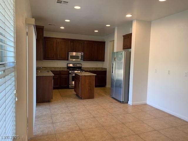 3728 Prairie Orchid Ave, North Las Vegas, NV 89081 - kitchen with stainless steel appliances, a center island, recessed lighting, a sink, and light tile patterned floors