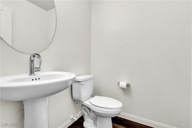 6952 Crescent Gold St, North Las Vegas, NV 89086 - bathroom with baseboards, toilet, wood finished floors, and a sink