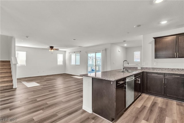 6952 Crescent Gold St, North Las Vegas, NV 89086 - kitchen with a sink, stainless steel dishwasher, open floor plan, dark brown cabinets, and healthy amount of natural light