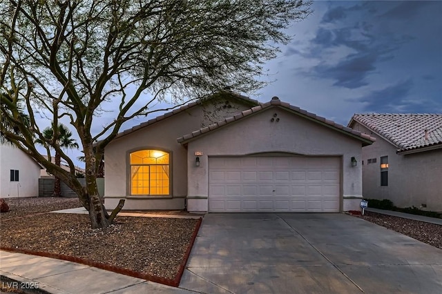 3426 Side Saddle Ct, North Las Vegas, NV 89032 - mediterranean / spanish-style house featuring a garage, stucco siding, driveway, and a tile roof