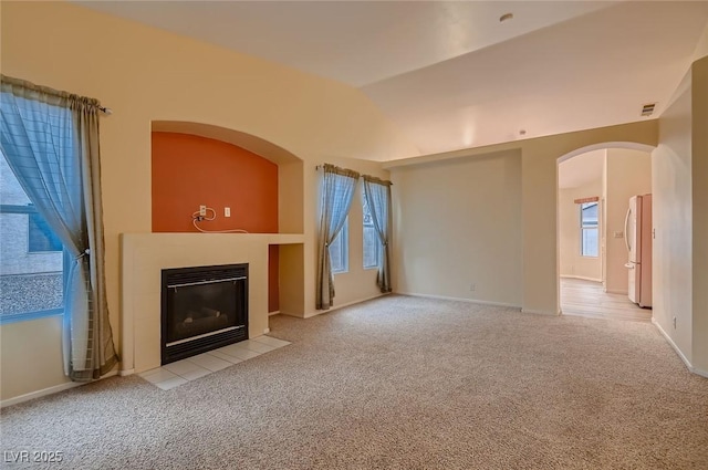 3426 Side Saddle Ct, North Las Vegas, NV 89032 - unfurnished living room featuring a fireplace with flush hearth, carpet, arched walkways, and baseboards