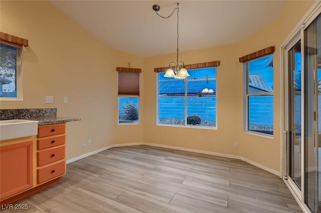 3426 Side Saddle Ct, North Las Vegas, NV 89032 - unfurnished dining area with a chandelier, light wood-style floors, and baseboards