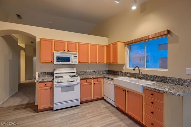 3426 Side Saddle Ct, North Las Vegas, NV 89032 - kitchen featuring white appliances, a sink, arched walkways, light wood-style floors, and high vaulted ceiling