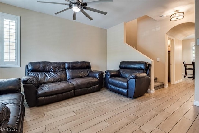 7694 Hampton Park Ln, Las Vegas, NV 89113 - living area with arched walkways, ceiling fan, light wood-style flooring, healthy amount of natural light, and vaulted ceiling