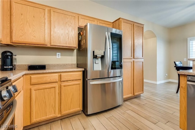 7694 Hampton Park Ln, Las Vegas, NV 89113 - kitchen with appliances with stainless steel finishes, arched walkways, light brown cabinets, and light wood-style flooring