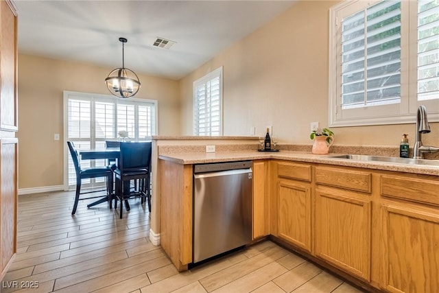 7694 Hampton Park Ln, Las Vegas, NV 89113 - kitchen with stainless steel dishwasher, a sink, light countertops, light wood-style floors, and a chandelier
