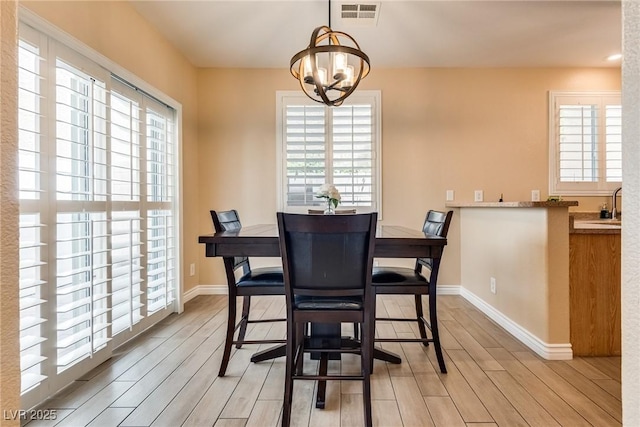 7694 Hampton Park Ln, Las Vegas, NV 89113 - dining area featuring healthy amount of natural light, light wood-type flooring, and a chandelier