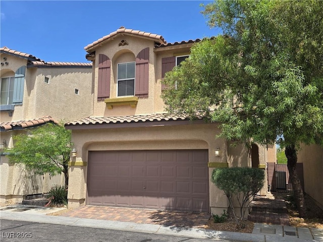 9312 Gold Dove Ct, Las Vegas, NV 89178 - mediterranean / spanish-style home with stucco siding, an attached garage, decorative driveway, and a tiled roof