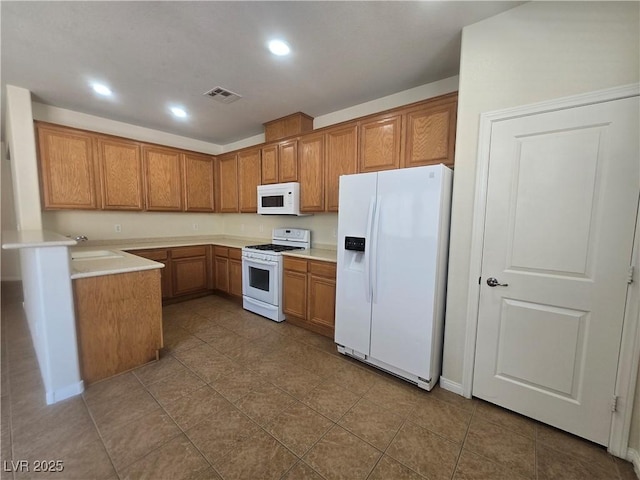 9312 Gold Dove Ct, Las Vegas, NV 89178 - kitchen featuring white appliances, brown cabinetry, a sink, light countertops, and recessed lighting