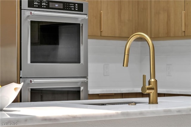 7738 Willow Cove Cir, Las Vegas, NV 89129 - kitchen view of double oven, a sink, light countertops, modern cabinets, and brown cabinets