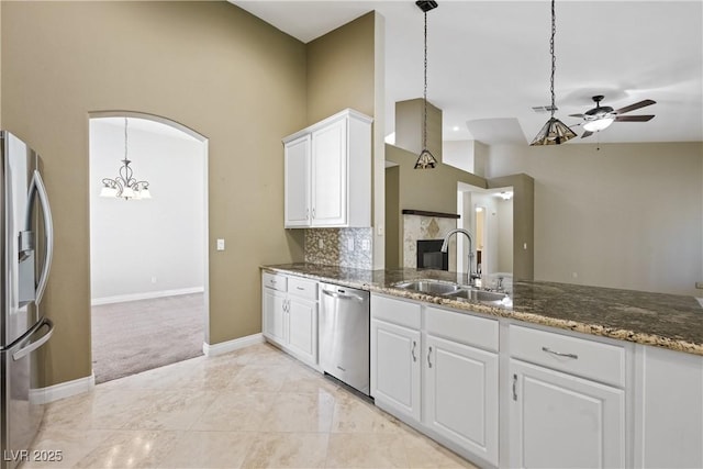 8541 Highland View Ave, Las Vegas, NV 89145 - kitchen with appliances with stainless steel finishes, a sink, ceiling fan, white cabinetry, and dark stone counters