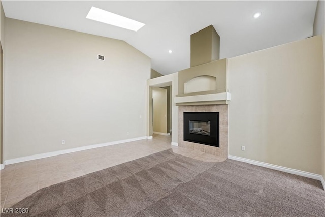 8541 Highland View Ave, Las Vegas, NV 89145 - unfurnished living room with a tile fireplace, vaulted ceiling, a skylight, carpet, and baseboards