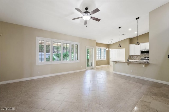 8541 Highland View Ave, Las Vegas, NV 89145 - unfurnished living room featuring a ceiling fan, vaulted ceiling, baseboards, light tile patterned floors, and a sink