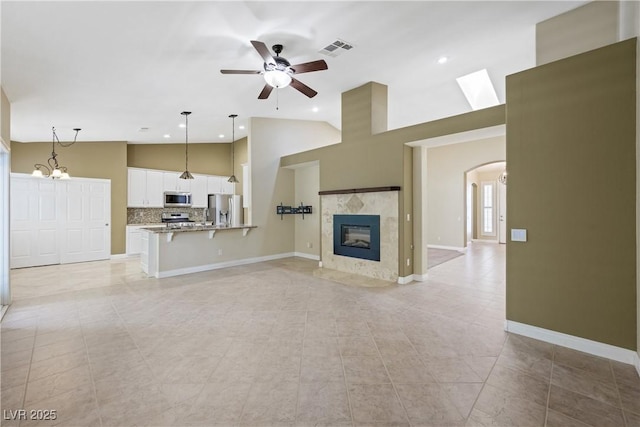 8541 Highland View Ave, Las Vegas, NV 89145 - unfurnished living room featuring a ceiling fan, arched walkways, a fireplace, light tile patterned flooring, and baseboards