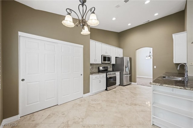 8541 Highland View Ave, Las Vegas, NV 89145 - kitchen featuring stainless steel appliances, a sink, a chandelier, white cabinetry, and arched walkways