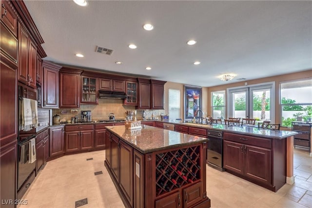 2982 Hammerwood Dr, Las Vegas, NV 89135 - kitchen with a peninsula, a center island, recessed lighting, under cabinet range hood, and backsplash