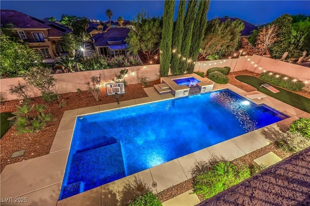 2982 Hammerwood Dr, Las Vegas, NV 89135 - pool at night with an in-ground hot tub, an outdoor pool, a fenced backyard, and a patio