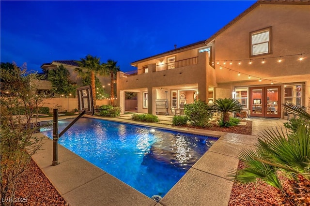 2982 Hammerwood Dr, Las Vegas, NV 89135 - pool at twilight featuring french doors, an outdoor pool, and a patio area