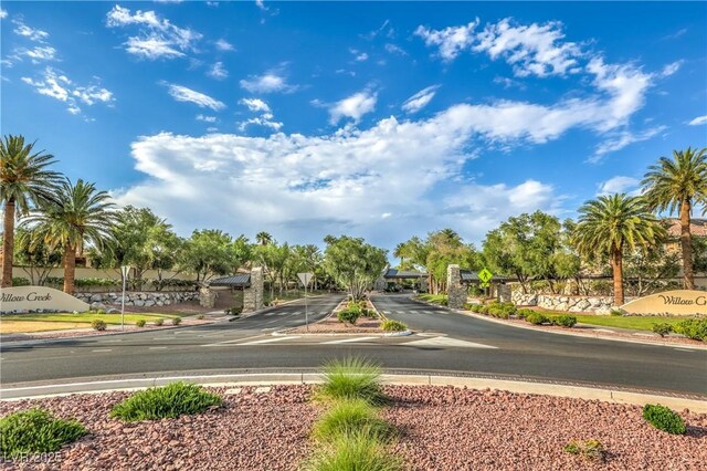 2982 Hammerwood Dr, Las Vegas, NV 89135 - view of asphalt road featuring curbs, traffic signs, and a gated entry