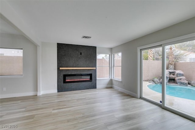 71 Sea Holly Way, Henderson, NV 89074 - unfurnished living room with wood finished floors, a large fireplace, and baseboards