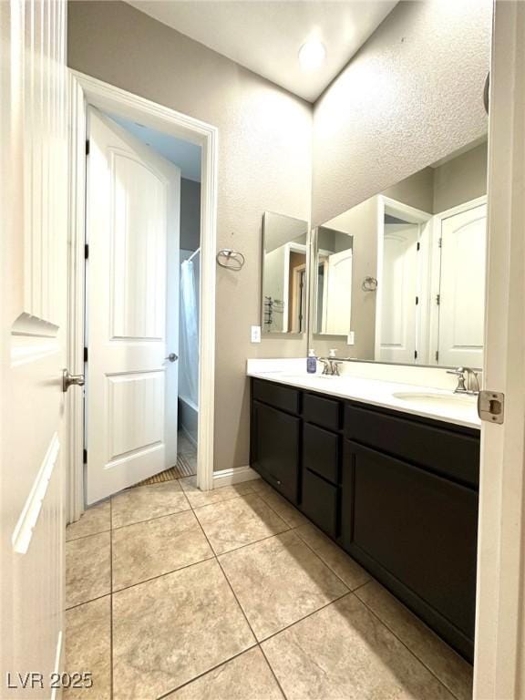 10719 Hammett Park Ave, Las Vegas, NV 89166 - full bath with double vanity, tile patterned floors, curtained shower, and baseboards