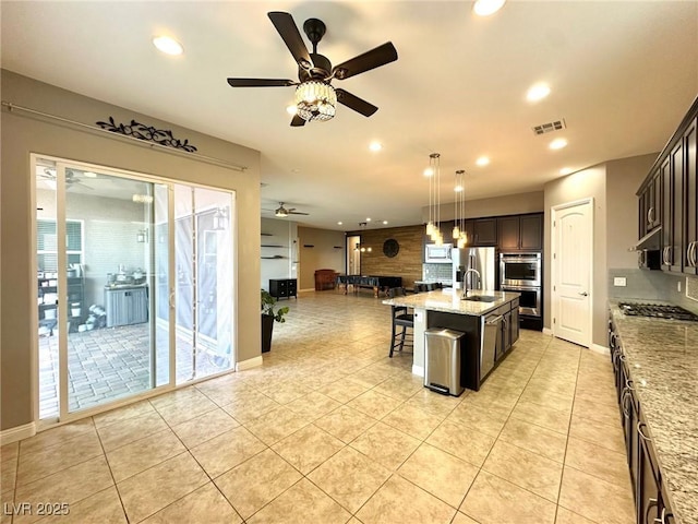 10719 Hammett Park Ave, Las Vegas, NV 89166 - kitchen with appliances with stainless steel finishes, open floor plan, ceiling fan, backsplash, and light tile patterned flooring