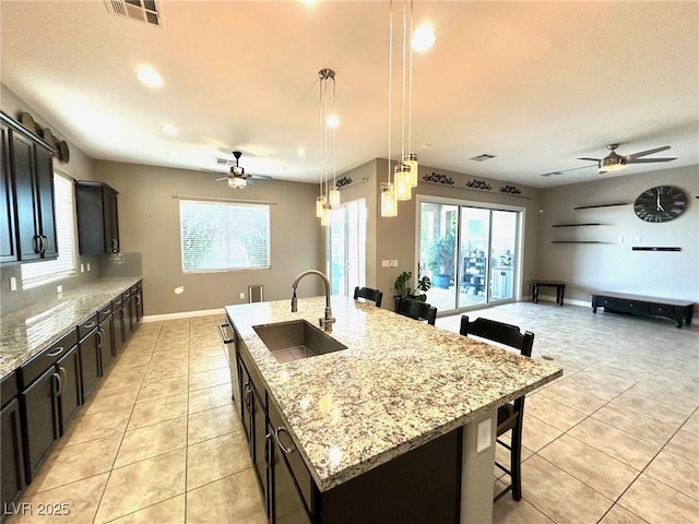 10719 Hammett Park Ave, Las Vegas, NV 89166 - kitchen featuring a sink, ceiling fan, a kitchen bar, light tile patterned floors, and recessed lighting