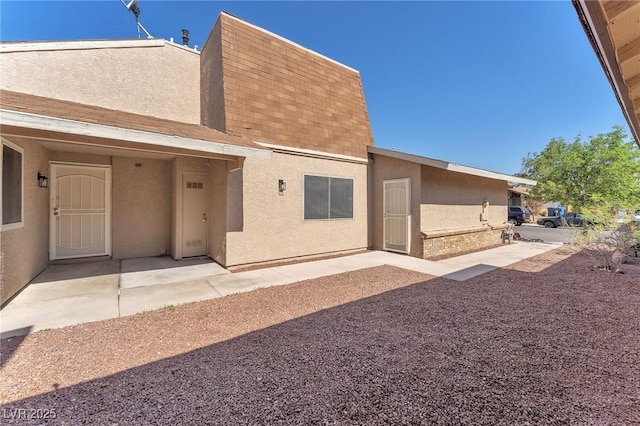 6717 Sheffield Dr, Las Vegas, NV 89108 - back of property featuring stucco siding, a patio area, brick siding, and a shingled roof