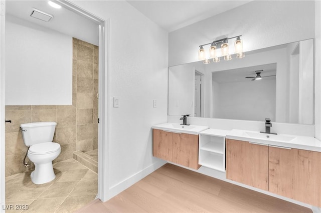 6717 Sheffield Dr, Las Vegas, NV 89108 - bathroom with double vanity, ceiling fan, tiled shower, tile walls, and wood finished floors