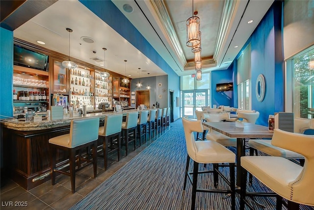 145 E Harmon Ave Unit 1120, Las Vegas, NV 89109 - tiled dining area featuring a tray ceiling, plenty of natural light, ornamental molding, a community bar, and recessed lighting