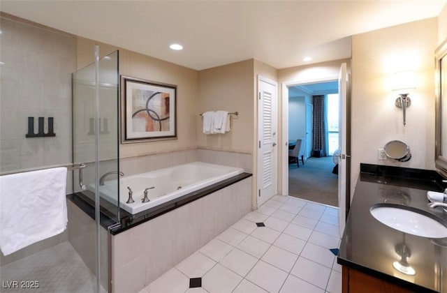 145 E Harmon Ave Unit 1120, Las Vegas, NV 89109 - bathroom with double vanity, a jetted tub, a stall shower, tile patterned floors, and recessed lighting