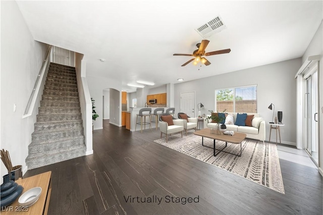 9312 Straw Hays St Unit 103, Las Vegas, NV 89178 - living area with arched walkways, stairway, wood finished floors, and ceiling fan