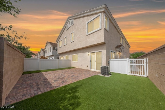 9312 Straw Hays St Unit 103, Las Vegas, NV 89178 - back of house at dusk with a patio, a fenced backyard, and stucco siding