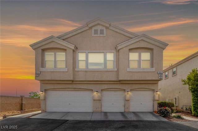 9312 Straw Hays St Unit 103, Las Vegas, NV 89178 - view of front facade featuring asphalt driveway, a garage, and stucco siding