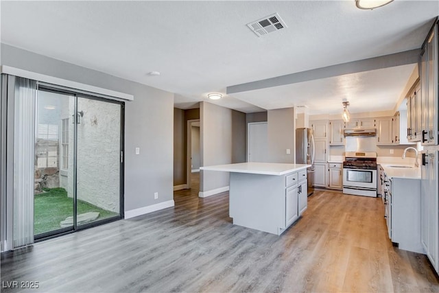 3971 Foxboro Cir, Las Vegas, NV 89121 - kitchen featuring appliances with stainless steel finishes, under cabinet range hood, a center island, and light countertops