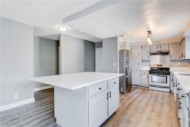 3971 Foxboro Cir, Las Vegas, NV 89121 - kitchen with appliances with stainless steel finishes, under cabinet range hood, light countertops, light wood-style flooring, and a center island