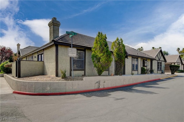 3971 Foxboro Cir, Las Vegas, NV 89121 - view of property exterior featuring a chimney, stucco siding, and a tiled roof