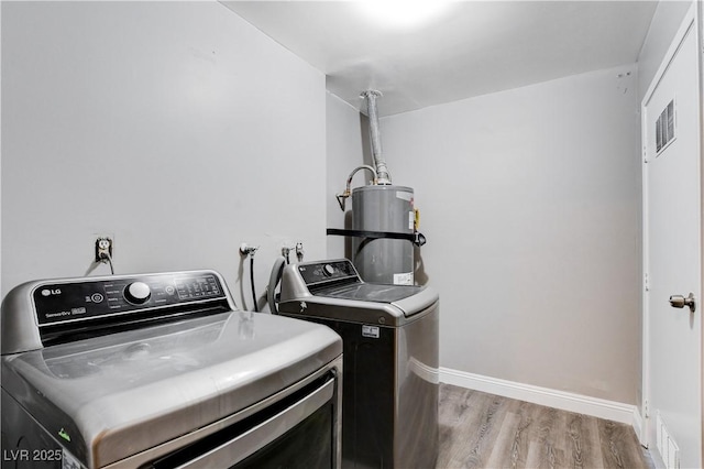 3971 Foxboro Cir, Las Vegas, NV 89121 - washroom with strapped water heater, separate washer and dryer, wood finished floors, and baseboards