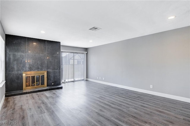 3971 Foxboro Cir, Las Vegas, NV 89121 - unfurnished living room featuring baseboards, wood finished floors, a tiled fireplace, and recessed lighting