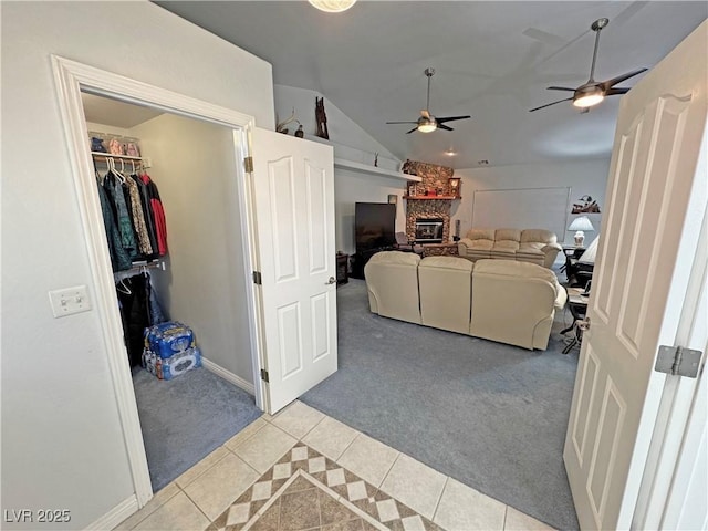 3451 Sagebrush Ave, Pahrump, NV 89048 - living room with light colored carpet, light tile patterned flooring, lofted ceiling, a fireplace, and a ceiling fan