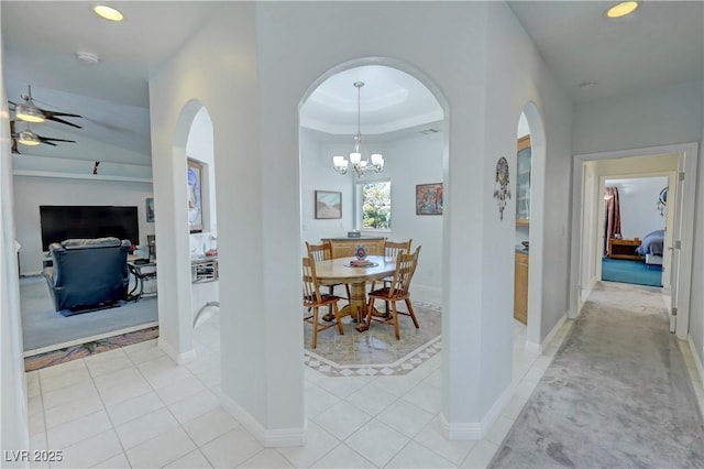 3451 Sagebrush Ave, Pahrump, NV 89048 - corridor featuring baseboards, arched walkways, recessed lighting, light tile patterned flooring, and a tray ceiling