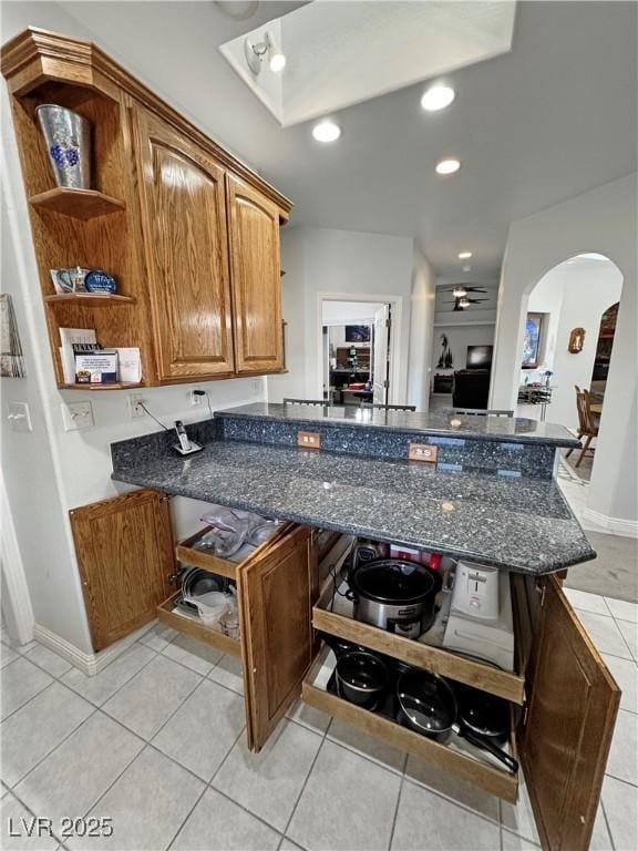 3451 Sagebrush Ave, Pahrump, NV 89048 - kitchen featuring open shelves, arched walkways, light tile patterned floors, a peninsula, and recessed lighting