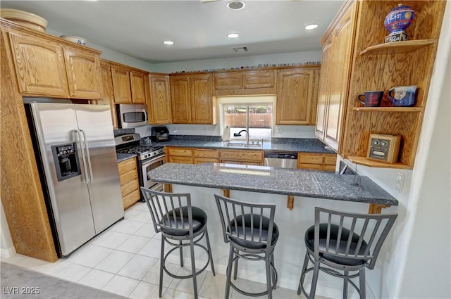 3451 Sagebrush Ave, Pahrump, NV 89048 - kitchen with appliances with stainless steel finishes, open shelves, a sink, a breakfast bar, and recessed lighting